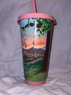 a cup with a pink lid sitting on top of a white sheet