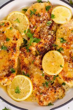 a white plate topped with chicken and lemon slices