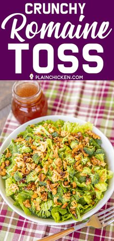 a white bowl filled with lettuce and nuts next to a jar of honey