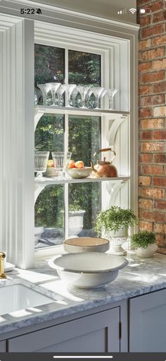 an open window in a kitchen with dishes on the counter