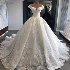 a white wedding dress on display in front of a mirror