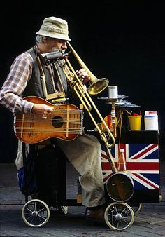 a man sitting on top of a cart holding a musical instrument