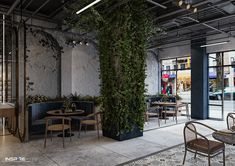 the interior of a restaurant with tables, chairs and plants growing on the wall behind them