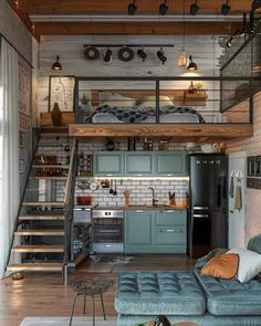 a loft apartment with stairs leading up to the kitchen