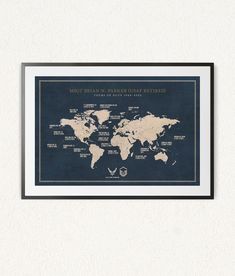 a framed world map with the names of major cities in blue and gold, hanging on a wall