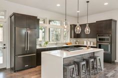 a large kitchen with an island and bar stools