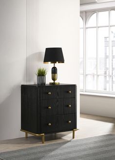 a black and gold chest of drawers with a lamp on it in front of a window