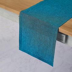 a blue table runner on top of a wooden table