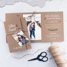 the wedding stationery is laid out with twine and some scissors next to it