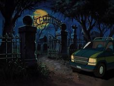 a green car parked in front of a gate at night with the moon behind it