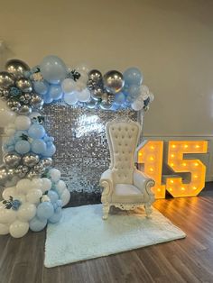 a chair and balloons in front of a large number 55 sign on a wooden floor