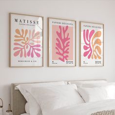 two framed posters on the wall above a bed