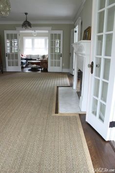 an empty living room with white doors and carpet