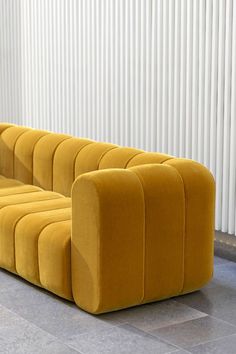 a yellow couch sitting on top of a tiled floor