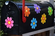 a black mailbox with colorful flowers painted on it's front and the bottom