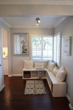 a living room filled with white furniture and lots of pillows on top of the couch