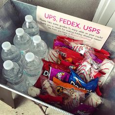 a metal container filled with lots of bottled water and snacks in front of a sign that reads ups, fedex, usps