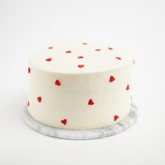 a white cake with red hearts on it