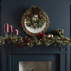 a mantel decorated for christmas with candles and wreaths