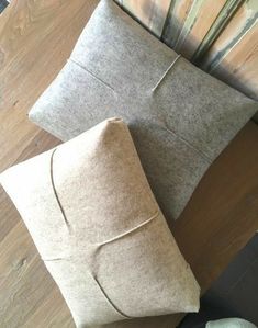 two pillows sitting next to each other on top of a wooden floor