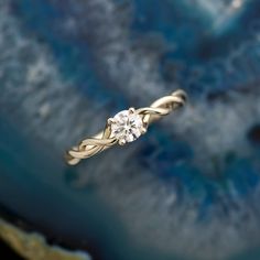 a diamond ring sitting on top of a blue and white background