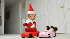 a baby elf riding on top of a toy car