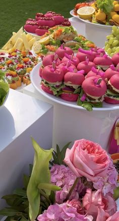 there are many different types of food on the table and one is decorated with pink flowers