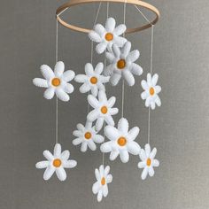 a mobile with white and orange flowers hanging from it