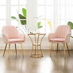 two pink chairs sitting next to each other on top of a hard wood floored floor