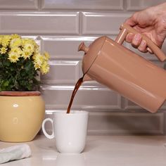 a person pours coffee into a mug