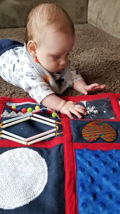 a baby laying on the floor playing with toys