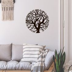 a living room filled with furniture and a tree wall decal