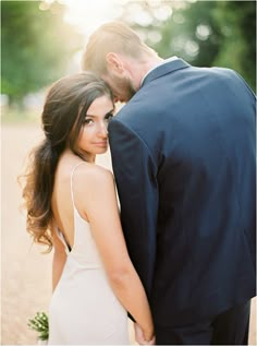 a man and woman standing next to each other in front of a photo on the phone