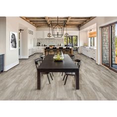 a large open kitchen and dining room with wood flooring that looks like it has been remodeled