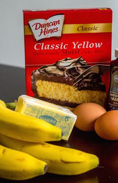 some bananas, eggs, and cake on a table next to a carton of butter