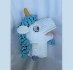 a crocheted white and blue stuffed animal with a horn on it's head