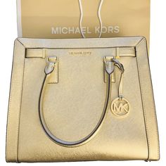 Michael Kors Large Dillion Satchel Crossbody Bag in Gold - The perfect gift comes with MK shopping bag and tags. No dust bag. Saffiano Leather Top Zip closure MK medallion hang charm on the front Gold tone hardware Michael Kors logo in front Flat bottom with protective feet Fully lined with matching MK Sateen Fabric Interior: 4 open pockets; 1 zippered pocket Approx Measurement: H 12” L 13” W 3.5” Dual handles drop 5.5" drop Adjustable/Removable shoulder crossbody strap 21"-25" drop Classic Gold Satchel With Branded Hardware, Classic Gold Satchel For Shopping, Modern Gold Satchel With Branded Hardware, Designer Gold Saffiano Leather Shoulder Bag, Michael Kors Gold Rectangular Satchel, Michael Kors Gold Travel Satchel, Michael Kors Gold Satchel For Travel, Gold Michael Kors Rectangular Satchel, Classic Gold Michael Kors Bag