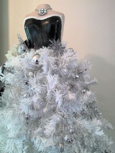 a white christmas tree decorated with silver ornaments