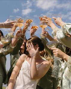 a group of women standing around each other holding wine glasses in front of their faces