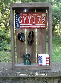 a wooden box with an american flag and hat hanging from it's sides on a stone wall