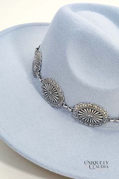 You know you need that one accessory to make all your favorite outfits shine with perfection. The Colorado Silver Medallion Chain Fedora Hat is chic and stylish, and it will definitely turn heads when you wear it. It features a gorgeous silver-tone medallion band, a tall crown design in a light grey (almost baby blue) color. 90% Polyester, and 10% Alloy Stiff Brim: 3.5" Crown: 4.75 Medallion Band Height: 1.5" 22" interior circumference with an internal drawstring Spot Clean Imported Western Silver Jewelry For Parties, Western Style Silver Party Jewelry, Western Style Silver Jewelry For Party, Western Silver Hat Bands For Festivals, Silver Western Hat Bands For Festival, Western Style Silver Hat With Flat Brim, Western Silver Hats For Summer, Elegant Silver Hat With Flat Brim, Trendy Silver Summer Hat