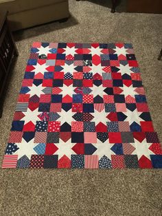 a red, white and blue quilt on the floor