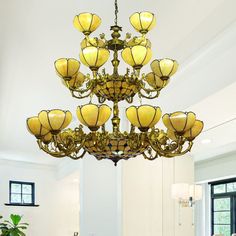 a large chandelier hanging from the ceiling in a room with white walls and windows