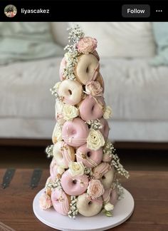 a cake made to look like a donut tower with flowers on top and doughnuts in the middle