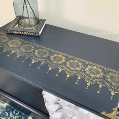 a black table with gold paint on it and a book sitting on top of it