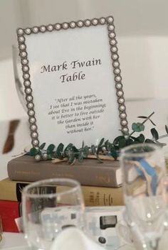 the table is set with books, glasses and silverware for guests to sit at