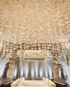 the ceiling is decorated with white flowers and branches for an elegant wedding ceremony at the four seasons hotel in las vegas