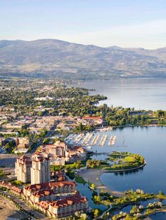 an aerial view of a city and the water with mountains in the backgroud