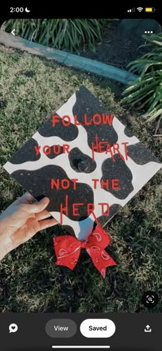 someone is holding up a graduation cap with the words follow your heart not the herd on it