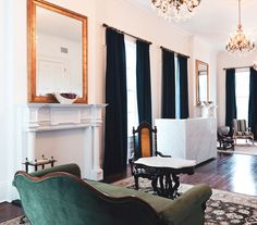 a living room filled with furniture and a fire place in front of a mirror on the wall